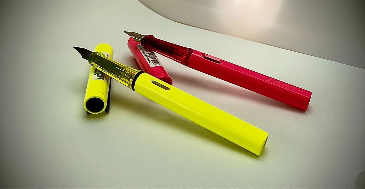 Lime-yellow and pink-red LAMY fountain pens displayed together